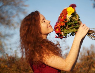 Bir buket çiçekli güzel bir kadın..