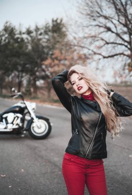Bir motosiklet üzerinde yol ile poz bir şık motorcu kadın.