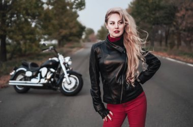 Bir motosiklet üzerinde yol ile poz bir şık motorcu kadın.