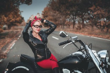 Motosiklet yol üzerinde şık bir kadınla. Pin-up tarzı.