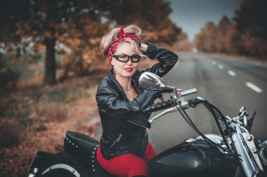Motosiklet yol üzerinde şık bir kadınla. Pin-up tarzı.