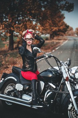 Motosiklet yol üzerinde şık bir kadınla. Pin-up tarzı.