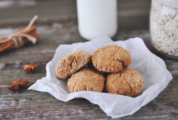 Oat cookies with ingredients on wooden background.