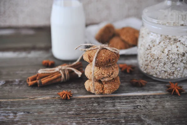 Oat cookies with ingredients on wooden background.