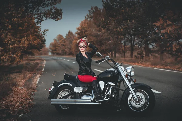 Biker woman with motorcycle on the road.