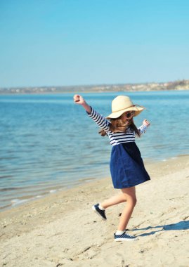 Şapkalı sevimli küçük kız açık havada eğlenceli.