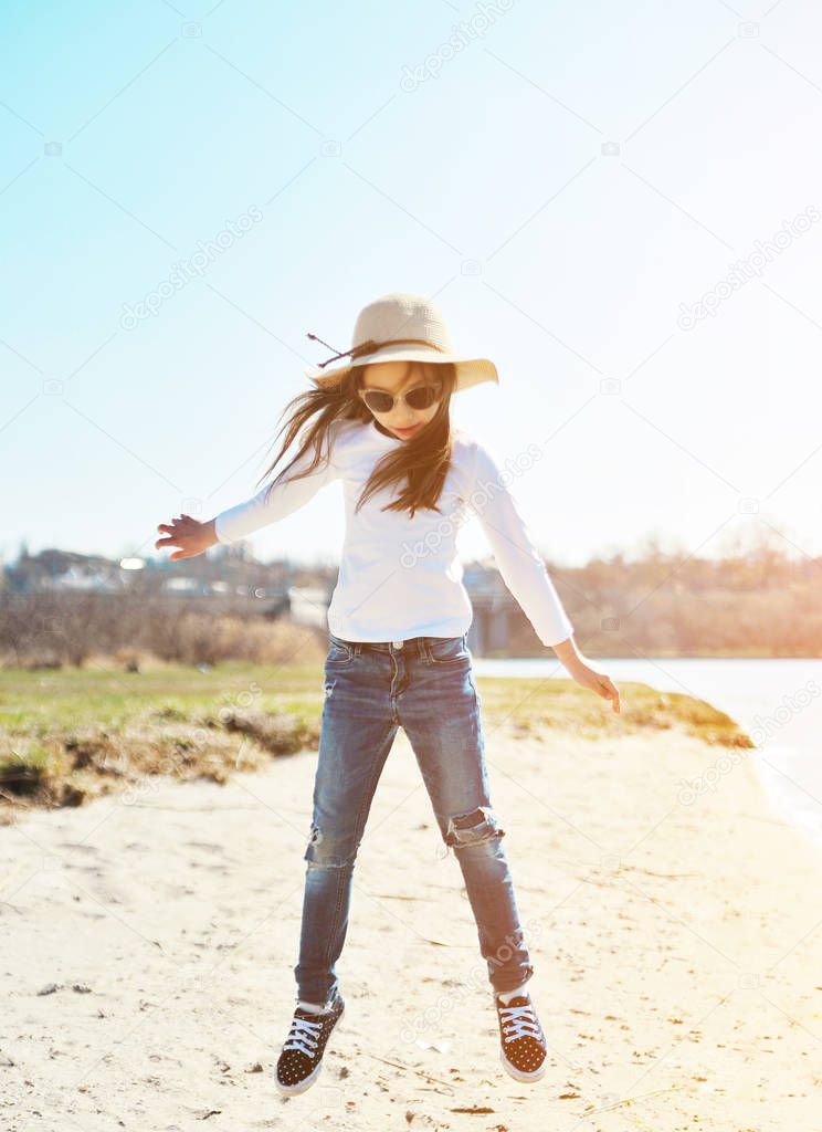 Cute little girl has a fun on the beach. Summertime concept.