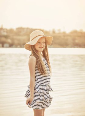 Sevimli küçük kız gün batımında sahilde bir eğlence var.