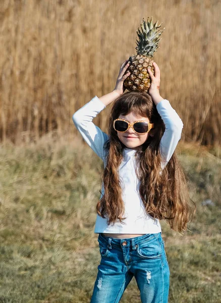 小可爱的女孩与菠萝在海滩上日落 — 图库照片