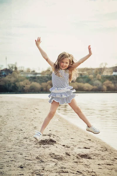 귀여운 소녀는 일몰에 해변에서 재미를 가지고 — 스톡 사진