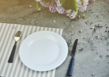 Çatal ve çiçek ile süslenmiş taş masa.