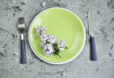 Çatal ve çiçek ile süslenmiş taş masa.