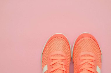 Sportif ayakkabı ve şişe pembe arka plan üzerinde.