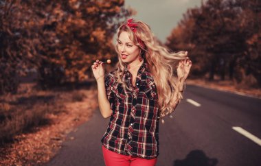 Güzel kadın içinde pin yukarı stil poz üzerinde yol.