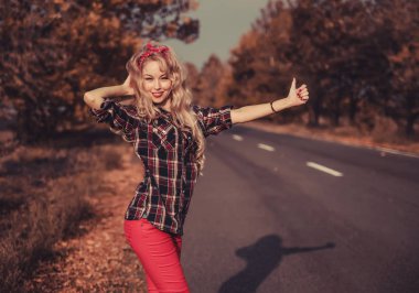 Güzel kadın içinde pin yukarı stil poz üzerinde yol.