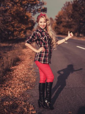 Güzel kadın içinde pin yukarı stil poz üzerinde yol.