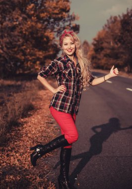 Güzel kadın içinde pin yukarı stil poz üzerinde yol.