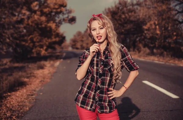 Güzel kadın içinde pin yukarı stil poz üzerinde yol.