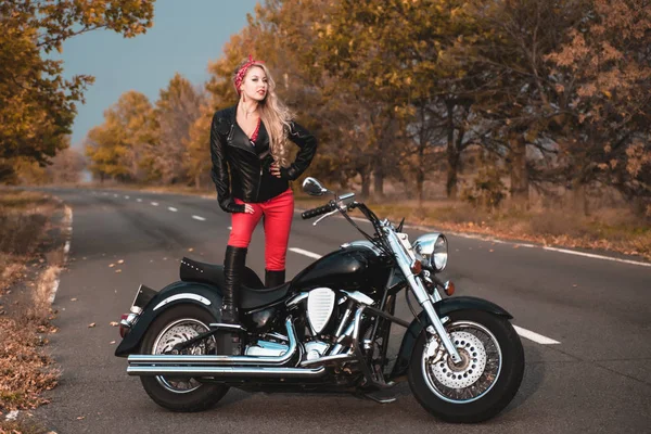 美しいバイクに乗る女性がオートバイの道路上でポーズ — ストック写真