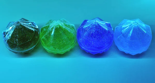 Bright slime with glitters in the diamond box on colorful background.