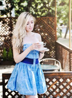 Güzel genç kadın latte fincan ile kafein poz.