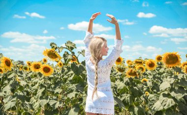 Güzel beyaz kadın ayçiçeği ile çayırda poz.