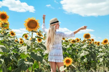 Güzel beyaz kadın ayçiçeği ile çayırda poz.