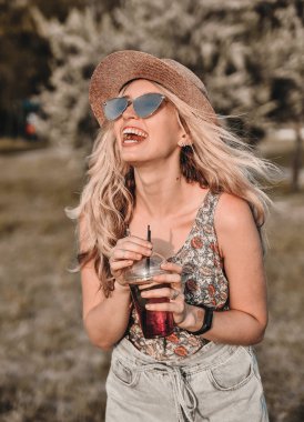Yaz soğuk içki ile şık şapka güzel genç kadın açık havada eğlenceli.