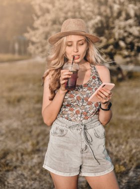 Yazın soğuk kokteyli olan şık şapkalı güzel genç bir kadın dışarıda eğleniyor..