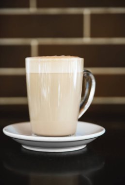 Siyah arka planda latte bir fincan. Siyah tuşla yapılan fotoğraf.