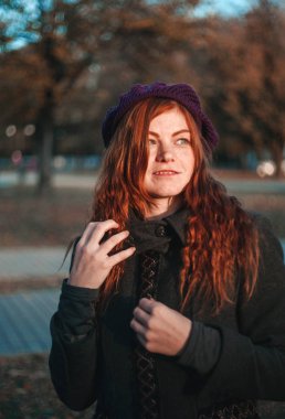 Sonbahar parkında şapka kırmızı saçlı kadın portresi. Siyah tuşla yapılan fotoğraf.