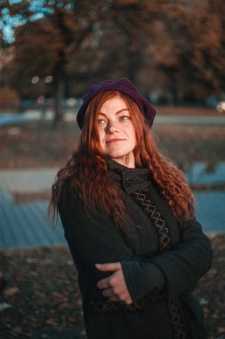 Sonbahar parkında şapka kırmızı saçlı kadın portresi. Siyah tuşla yapılan fotoğraf.