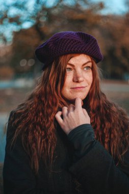Sonbahar parkında şapka kırmızı saçlı kadın portresi. Siyah tuşla yapılan fotoğraf.