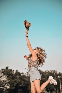 Şık şapkalı güzel genç kadın açık havada eğlenceli.