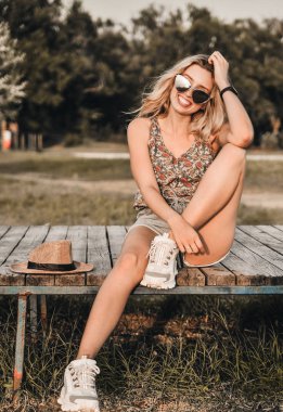 Şık şapkalı güzel genç kadın açık havada eğlenceli.