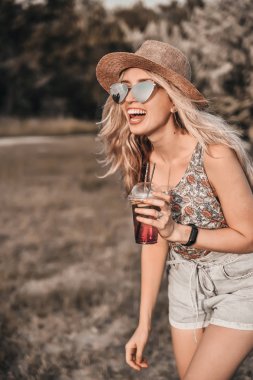 Şık şapkalı güzel genç kadın açık havada eğlenceli.