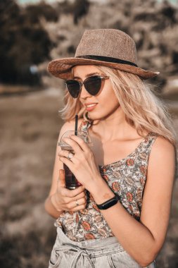 Şık şapkalı güzel genç kadın açık havada eğlenceli.
