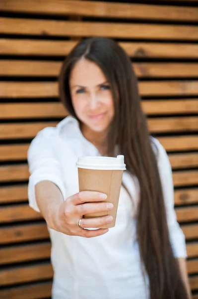 Beautiful young woman with paper cup of coffee in coffee house.