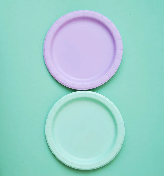 Colorful paper plates on light background.