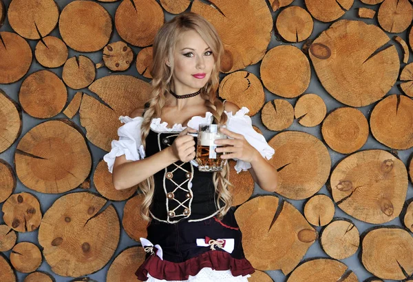 木製の背景にポーズをとる手でビールを持つ笑顔の美しい女性 オクトーバーフェストコンセプト — ストック写真