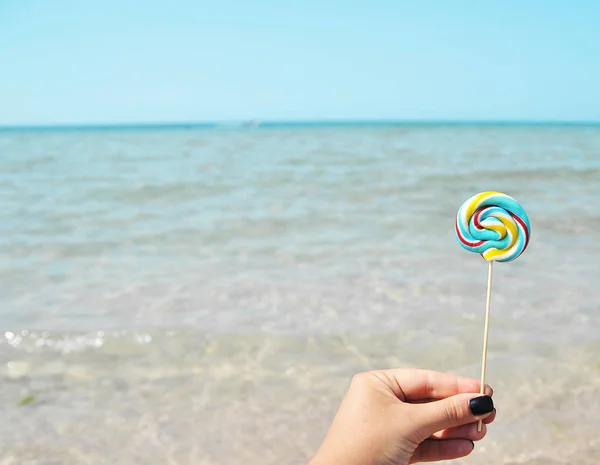 Mão Feminina Segura Doces Coloridos Fundo Mar — Fotografia de Stock