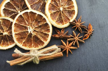 Noel baharatları arka planı. Tarçın, kurutulmuş portakal ve anason taştan arka planda.
