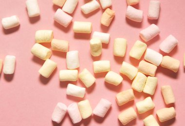 Pembe arka planda lezzetli marşmelovlar.