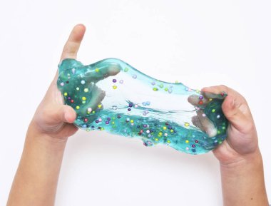 Çocuk beyaz arka planda mavi sümükle oynar.