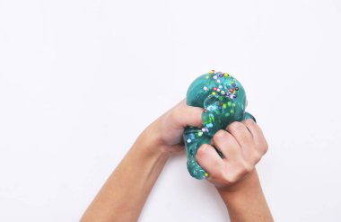 Çocuk beyaz arka planda mavi sümükle oynar.