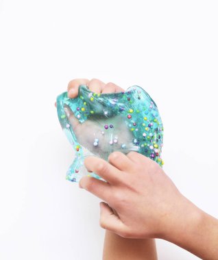 Çocuk beyaz arka planda mavi sümükle oynar.