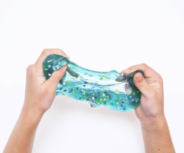 Çocuk beyaz arka planda mavi sümükle oynar.