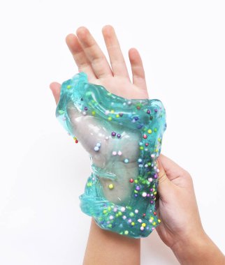 Çocuk beyaz arka planda mavi sümükle oynar.