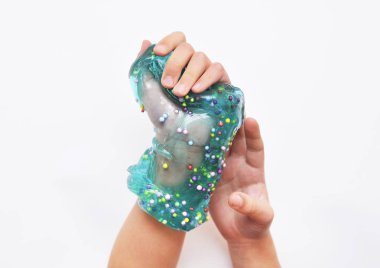 Çocuk beyaz arka planda mavi sümükle oynar.