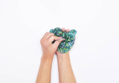 Çocuk beyaz arka planda mavi sümükle oynar.